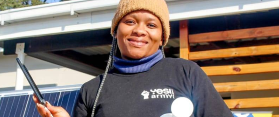 Matsepiso Majoro smiling and holding one of her solar-powered products