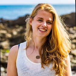 Imogen Napper in white tanktop with coastal background backdrop